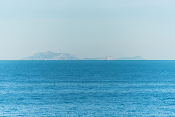Fototapeta na wymiar Blue Southern Italian Mediterranean Sea with Island in the Distance