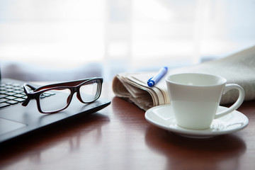 Newspaper with computer on table. Coffee break. 