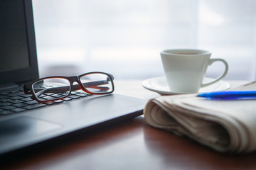 Newspaper with computer on table. Coffee break. 