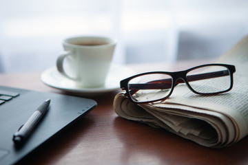 Newspaper with computer on table. Coffee break. 