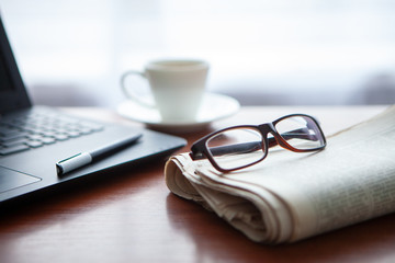 Newspaper with computer on table. Coffee break. 