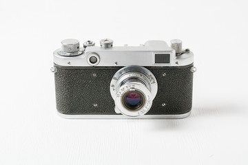 Old rangefinder vintage camera against white background with small lens. Range finder photo camera with lens. Classic black manual film camera.