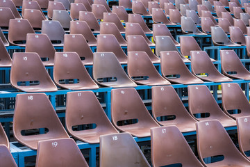 Rows of brown seats in a sports stadium