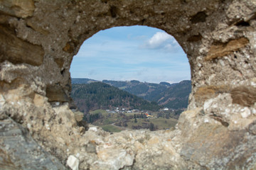 Fototapeta na wymiar a small town seen through a hole in an ancient wall