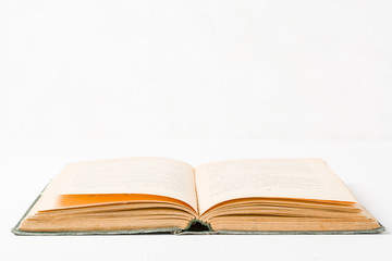 Old unfolded book lying on the table. Yellow paper pages. Plenty of space for text or photo.