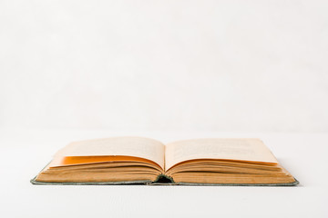 Old unfolded book lying on the table. Yellow paper pages. Plenty of space for text or photo.