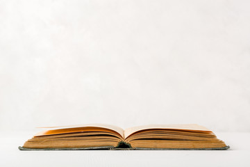 Old unfolded book lying on the table. Yellow paper pages. Plenty of space for text or photo.
