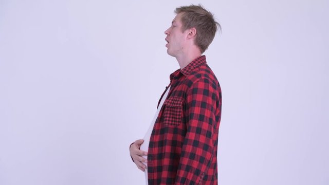 Profile view of young fat hipster man with big belly walking