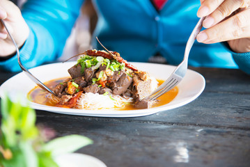 People eating spicy Northern Thai style noodle set - Thai food concept