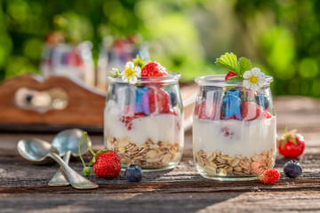 Homemade granola in jar with yoghurt and berries