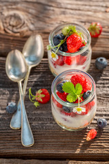 Delicious oat flakes with berries and yoghurt in jar