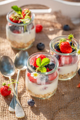 Delicious oat flakes in jar with yoghurt and berries