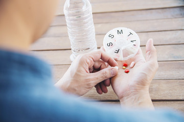 Naklejka premium People prepare daily medicine tablet in pillbox - people healthcare with medicine pills concept