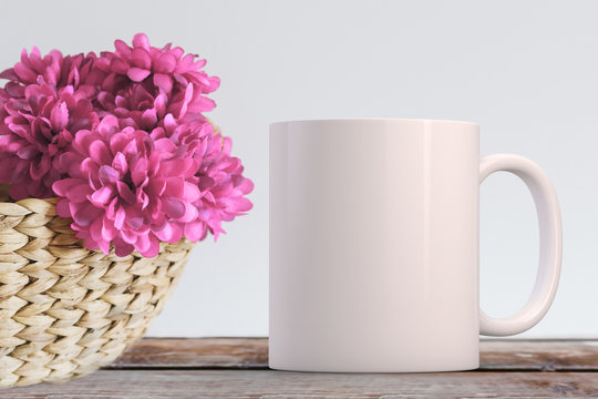 Blank White Mug coffee mug next to silk flowers in a basket. Perfect for businesses selling mugs, just overlay your quote or design on to the image.