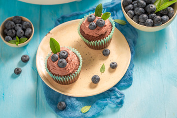 Sweet cupcake with blueberries and chocolate cream