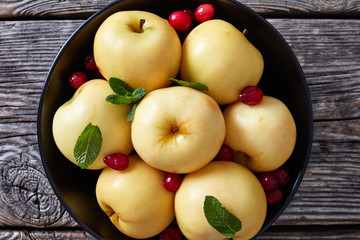 Pickled apples in a black bowl, close-up