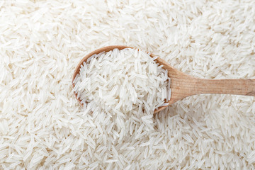 Raw white rice in a spoon.