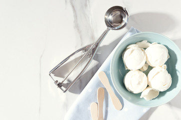 Sunny summer day.Vanilla ice cream balls, serving blue bowl,napkin and ice crem spoon, top view