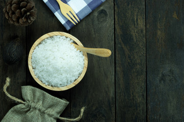 salt in a bowl and spoon on wood background