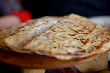 Azerbaijani food: flatbread qutab with meat and yogurt close-up on the table. Plate with Qutab.
