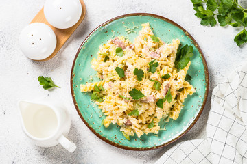 Pasta carbonara with zucchini in craft plate on white. 