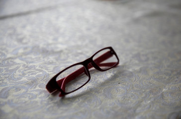 Fototapeta na wymiar Women's red eyeglasses on the table