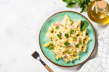 Pasta carbonara with zucchini in craft plate on white. 