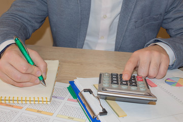A businessman doing some paperwork using his calculator. Businessperson working