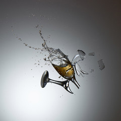 Collision of champagne glasses with shattered glass and champane splash