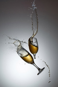 Collision of champagne glasses with shattered glass and champane splash