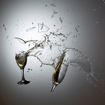Collision of champagne glasses with shattered glass and champane splash