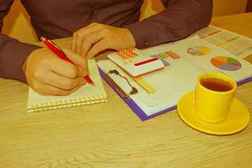 man working on office desk with Calculator, a pen and document. Man, counting money and making calculations