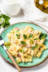 Pasta carbonara with zucchini in craft plate on white. 