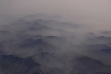 The tops of the mountains in the fog. View from above . Minimalism lines.