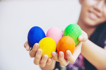 Fototapeta na wymiar Child showing colorful Easter eggs happily - Easter holiday celebration concept