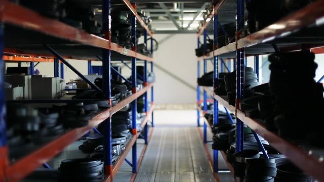 Inside the industrial warehouse of combine spare parts. Lots of metal shelves with boxes and packages.