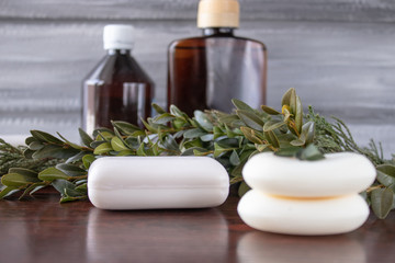 Cosmetic soap, cans of essential oil on a gray background.