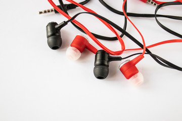 Black and red headphones on a white background from the right.