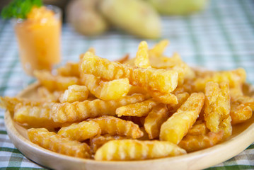 Delicious fried potato on wooden plate with dipped sauce - traditional fast food concept