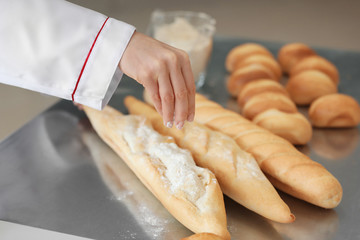 Female chef with freshly baked bakery products in kitchen