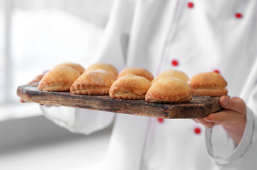 Female chef with freshly baked pastry in kitchen