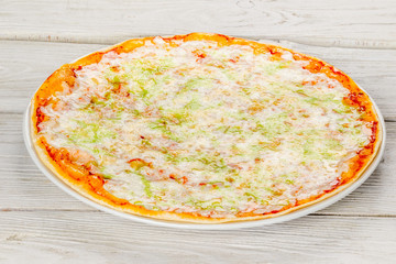 Cheese pizza filmed on white wooden background