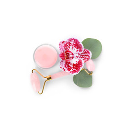 Facial massage tool with cosmetic product on white background