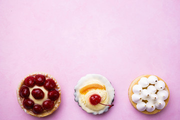 cakes background. delicious assorted desserts. cream cheese cupcake, berry tart, lemon meringue tart. home crafted sweet treats, confectionery