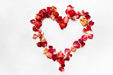 Red heart made from red rose petals on white background