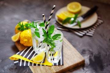 Refreshing summer beverage with lemon, mint and ice. Glasses with cold and healthy drink, place for text