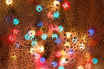 wet glass. cracks. lights through glass. warm background