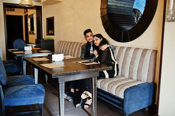 Lovely indian couple in love, wear at saree and elegant suit, posed on restaurant.