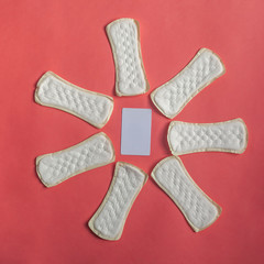 Feminine hygiene pad with blank white paper on red background