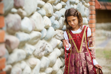 Girl in medieval attire near the old castle.